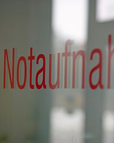 Notaufnahme steht in roter Schrift auf einer Glasoberfläche.